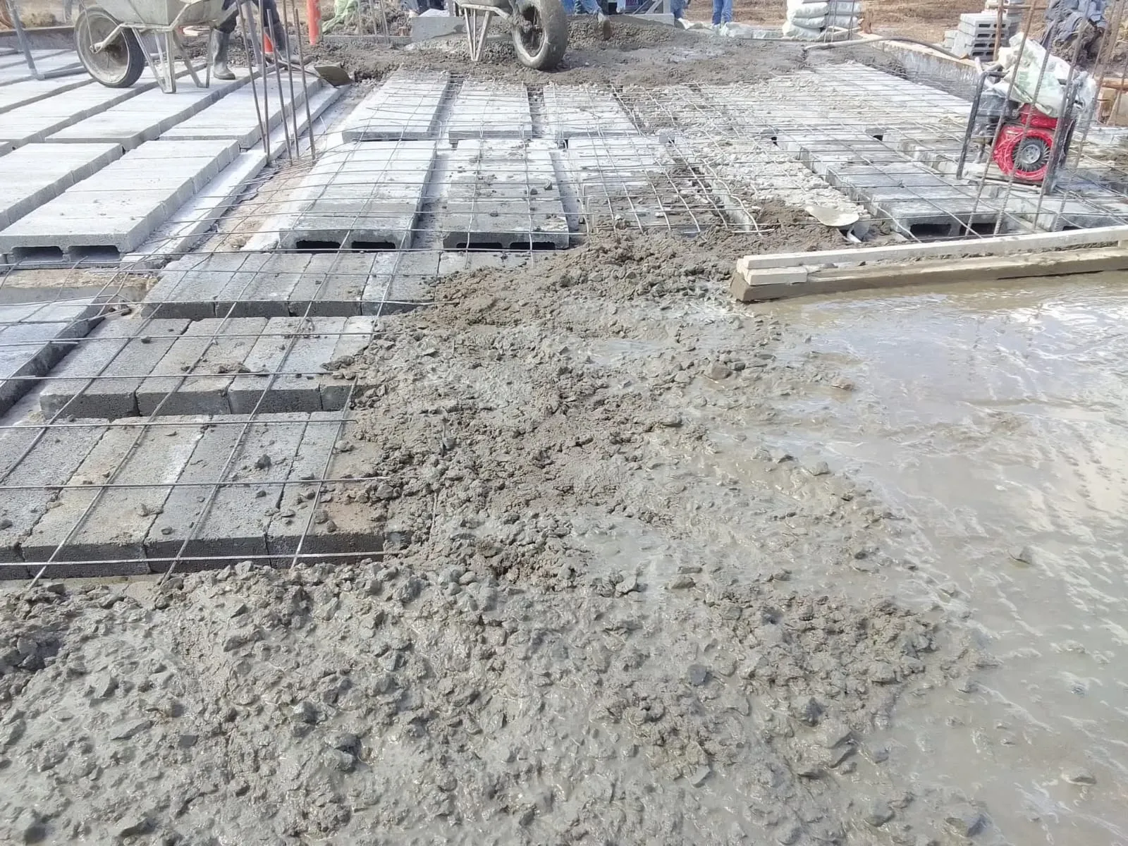 Concrete being poured over a reinforced slab installation